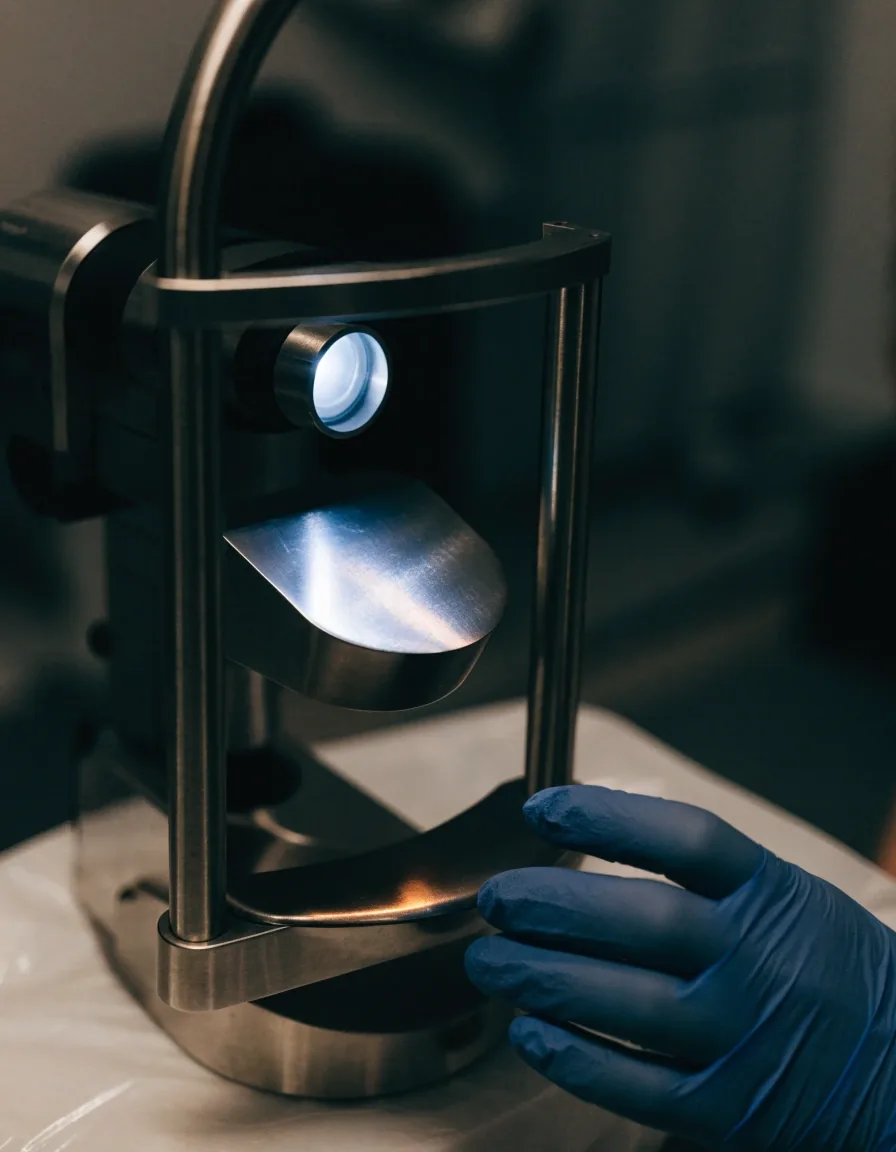 Side view of a slit lamp microscope cross-section in a darkened clinic
